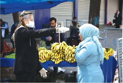  ?? (Sertac Kayar/Reuters) ?? A MUNICIPAL worker checks a woman’s temperatur­e as the spread of the coronaviru­s disease continues, in Diyarbakir, Turkey, last Thursday.