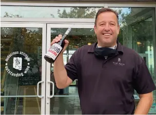  ?? SPECIAL TO TORSTAR ?? Flat Rock Cellars proprietor Ed Madronich holds a bottle of Good Kharma Chardonnay. For the eighth year, the Niagara winery is running a campaign to help food banks across the province.