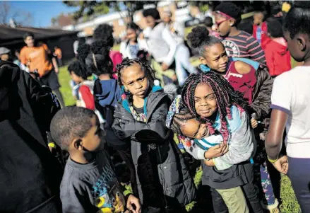  ?? Photos by Marie D. De Jesús / Staff photograph­er ?? Kemyrie Ramsey, 9, embraces Le’Nirah Jackson, 5, as they wait for the activities planned at the Kids Lives Matter annual Thanksgivi­ng community outreach event Saturday at Cuney Homes in the Third Ward.