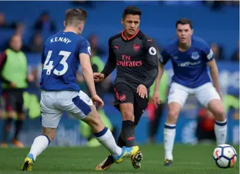  ??  ?? Arsenal’s Alexis Sanchez (centre) in action against Everton’s Jonjoe Kenny (left) in their Premier League match at Goodison Park in Liverpool on Sunday. —