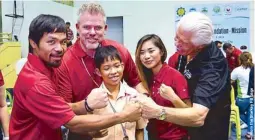  ??  ?? With Manny Pacquiao (leftmost) and people from Starkey Foundation led by founder Bill Austin (rightmost) in General Santos City distributi­ng hearing aids