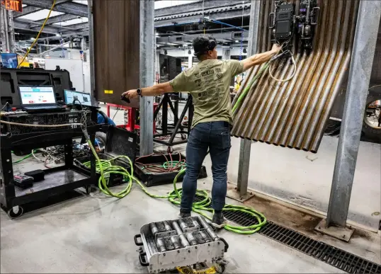  ?? Lucy Schaly/Post-Gazette photos ?? Luis Hermoso, a test lab engineer for Gecko Robotics on the North Side, puts a Toka 5 in place for a demo on Monday. Gecko Robotics was named a top 50 “disruptor” company by CNBC Tuesday, the first time a Pittsburgh company has made the national lineup since Duolingo in 2020.