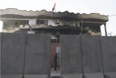  ?? Wakil Kohsar / AFP / Getty Images ?? The Iraqi Embassy in Kabul shows damage from the attack, which began when a suicide bomber blew himself up outside the entrance. Militants then breached the compound and engaged in a firefight.