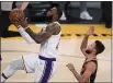  ?? PHOTO BY HARRY HOW — GETTY IMAGES ?? The Lakers’ LeBron James scores on a layup past the Warriors’ Stephen Curry during the second quarter on Sunday.