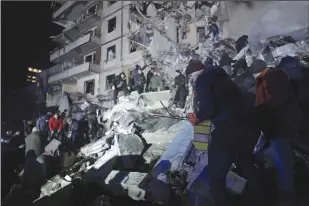  ?? VITALII MATOKHA/AFP VIA GETTY IMAGES ?? Rescuers works on a residentia­l building destroyed after a missile strike, in Dnipro, Ukraine, on Saturday.