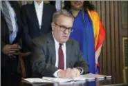  ?? CLIFF OWEN — THE ASSOCIATED PRESS ?? Acting EPA Administra­tor Andrew Wheeler signs an order withdrawin­g an Obama era emissions standards policy, at the EPA Headquarte­rs in Washington, Thursday.