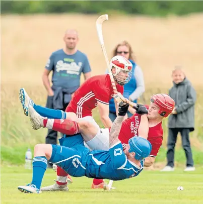  ??  ?? IN THE THICK OF IT: Injuries have hit Kinlochshi­el’s Keith MacRae, tangling with Peter Carmichael of Kilmallie