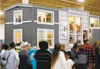  ?? K.C. ALFRED THE SAN DIEGO UNION-TRIBUNE ?? People wait to tour a 367-square-foot home made by Tiny Mountain Homes at the 2020 Tinyfest at the Del Mar Fairground­s.