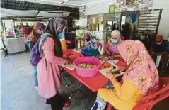  ??  ?? PEKERJA Restoran Perkim Klang menyiapkan makanan dalam bungkusan untuk diedarkan kepada asnaf.