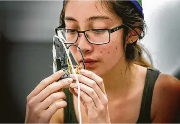  ?? Irfan Khan / Los Angeles Times ?? Lauren Hu, 20, works on her group project “Sleep Dep Buddy,” a light-sensitive robot that makes a ruckus if its owner doesn’t turn off the light and go to bed in time to get enough sleep. Harvey Mudd students organized a hardware “Hackathon” to create...