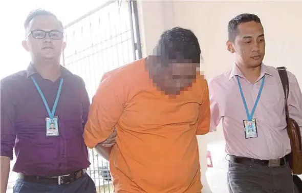  ?? PIC BY SHARUL HAFIZ ZAM ?? The suspect being led out of a court lock-up in Alor Star yesterday.