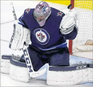  ?? CP PHOTO ?? Winnipeg Jets goalie Connor Hellebuyck saves the puck during third period NHL action against the Minnesota Wild in Winnipeg on Nov. 27.