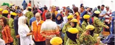  ??  ?? Government agencies and volunteers assisting fire victims at the Likas community hall yesterday.