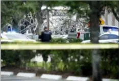  ?? BRYNN ANDERSON — THE ASSOCIATED PRESS ?? A police officer guards the area after an explosion on Saturday in Plantation, Fla. Several people were injured after a vacant pizza restaurant exploded in the South Florida shopping plaza Saturday, according to police. The restaurant was destroyed, and nearby businesses were damaged.