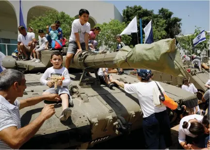  ??  ?? YOUNGSTERS PLAY on a tank as part of the celebratio­ns for Israel’s Independen­ce Day marking the 69th anniversar­y.