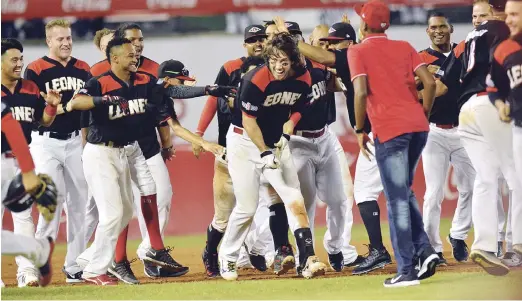  ??  ?? Un feliz Ryan Court es felicitado por sus compañeros del Escogido luego de haber dado el decisivo hit en el noveno contra los Tigres anoche en el Estadio Quisqueya Juan Marichal.