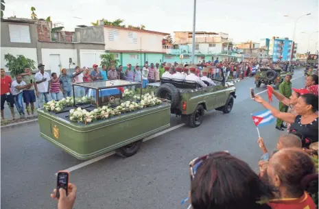  ?? JACK GRUBER, USA TODAY ?? Fidel Castro’s ashes pass by lines of people in the streets to his funeral service Sunday in Santiago de Cuba.