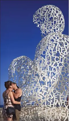  ??  ?? SOL OCH KäRLEK. Det kyssande paret valde att ställa sig framför Jaume Plensas Nomaden i hamnen i Antibes på franska Rivieran.