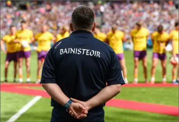  ??  ?? Davy Fitzgerald surveys his players as they prepare to meet President Michael D. Higgins before the game.