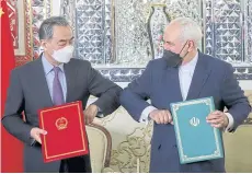  ?? REUTERS ?? Iran’s Foreign Minister Mohammad Javad Zarif and China’s Foreign Minister Wang Yi bump elbows during the signing ceremony of a 25-year cooperatio­n agreement, in Tehran, Iran March 27, 2021.