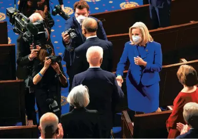  ?? CHIP SOMODEVILL­A/GETTY-AFP ?? President Joe Biden, center, greets Rep. Liz Cheney, R-Wyo., with a fist bump before addressing a joint session in the House chamber of the Capitol on April 28.