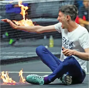  ?? ?? Flames: The activist screams in pain after setting his arm on fire at the Laver Cup in London