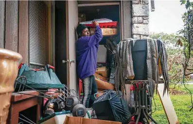  ?? Photos by Mark Mulligan / Staff photograph­er ?? Patricia Moon pulls some of her belongings from a storage closet outside her apartment at the Fort Crockett apartments last weekend in Galveston. The complex, owned by Landry’s Inc., is being shut down due to damage from the February freeze.