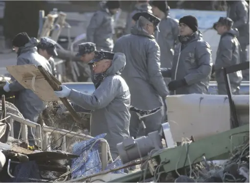  ?? Yomiuri Shimbun file photo ?? U.S. Marine personnel remove debris on Oshima island in Miyagi Prefecture on April 3, 2011.