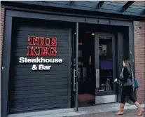  ?? CP PHOTO ?? A woman walks into a Keg Steakhouse and Bar in Yaletown in downtown Vancouver, B.C., on Nov. 19, 2013.