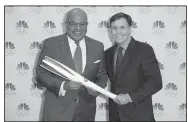  ??  ?? Veteran sports announcer Bob Costas (right) hands the Olympic torch to Mike Tirico, who will make his debut as NBC’s prime-time Olympics host at The Winter Olympics in PyeongChan­g.