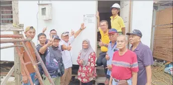  ?? ?? Yap (standing on stairs) joins Jubaidah and other villagers in a group photo, taken after the handover ceremony.