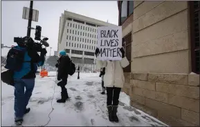  ?? (AP Photo/Christian Monterrosa) ?? A woman holds a Black Lives Matter sign outside of the Warren E. Burger Federal Building Thursday in St. Paul, Minn.