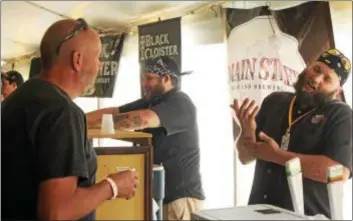  ?? THE NEWS-HERALD FILE ?? Todd Barrett of Mentor talks with Mike Mallone of Main Street while getting a sample of Main Street craft brew at Mentor On Tap.