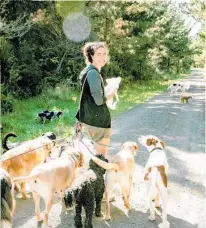  ?? Photos / Babiche Martens ?? Leda Taylor (below and with fiancee Camille, left) walking her pack in Riverhead Forest. She and Camille walk up to 30 dogs at a time on a daily basis.