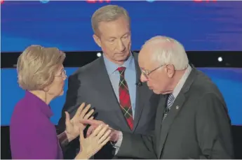  ?? SCOTT OLSON/GETTY IMAGES ?? Sen. Elizabeth Warren and Sen. Bernie Sanders speak as Tom Steyer looks on after the Democratic presidenti­al debate at Drake University on Tuesday in Des Moines, Iowa.