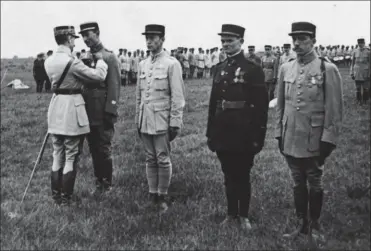  ?? BDIC ?? Au PlessisBel­leville le 1er septembre 1918, le gén. Duval, chef de la Division aérienne, décore ses meilleurs pilotes. De gauche à droite : le cne Hubert de Geffrier, le s-lt Louis Risacher, le s-lt René Dousinelle et le s-lt André Martenot de Cordoux.