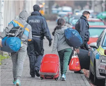  ?? FOTO: SEBASTIAN WILLNOW, DPA ?? Polizisten holen abgelehnte Asylbewerb­er für die Abschiebun­g ab. In Baden-Württember­g ist die Härtefallk­ommission für ausreisepf­lichtige Flüchtling­e die letzte Hoffnung, hier bleiben zu dürfen.