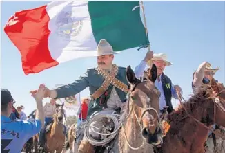  ??  ?? HORSEBACK RIDERS, some dressed like Pancho Villa, from the U.S. and Mexico were greeted warmly after traveling three miles from the border into Columbus, N.M., as part of the festivitie­s.