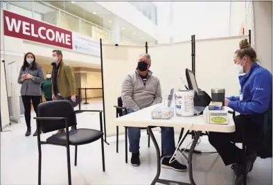  ?? Tyler Sizemore / Hearst Connecticu­t Media ?? Norwalk's Kevin Angers checks in during the grand opening of the COVID-19 vaccine “super site” at Silicon Harbor in Stamford on Monday. The site came to fruition through a partnershi­p between the city of Stamford, Stamford Health and BLT. The South End site hopes to vaccinate up to an additional 7,000 people per week.