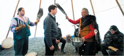  ?? CP PHOTO ?? Prime Minister Justin Trudeau receives a water cleansing by spiritual leader Cecil Grinder along with Chiefs of the Tsilhqot’in National Government near Chilko Lake on Friday. The prime minister was in the area to apologize to the Tsilhqot’in people for the hangings of six chiefs during the Chilcotin War over 150 years ago.