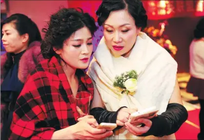  ?? WANG BIAO / FOR CHINA DAILY ?? Two women business owners exchange contact details at a party for entreprene­urs to celebrate the Internatio­nal Women’s Day on March 8, in Fuyang, Anhui province.