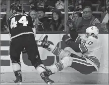  ?? The Associated Press ?? Los Angeles Kings centre Nate Thompson dumps Vancouver Canucks centre Nic Dowd in Los Angeles, Monday. The Kings won 3-0.