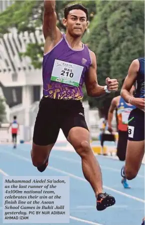  ?? PIC BY NUR ADIBAH AHMAD IZAM ?? Muhammad Aiedel Sa’adon, as the last runner of the 4x100m national team, celebrates their win at the finish line at the Asean School Games in Bukit Jalil yesterday.