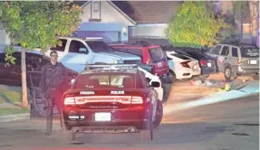  ?? RON HOLMAN/USA TODAY NETWORK ?? An officer waits as Fresno Police investigat­e a shooting Sunday. The shooting left four dead and six wounded.