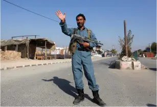  ?? (Omar Sobhani/Reuters) ?? AN AFGHAN POLICEMAN keeps watch near the Bagram Airfield entrance gate yesterday, after an explosion at the NATO air base, north of Kabul.