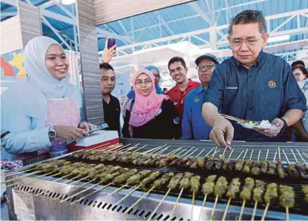  ?? PIC BY ROSELA ISMAIL ?? Agricultur­e and Agro-based Industry Minister Datuk Salahuddin Ayub visiting a booth after launching the Fisheries Department’s excellence programme at the Malaysia Agro Exposition Park Serdang yesterday.