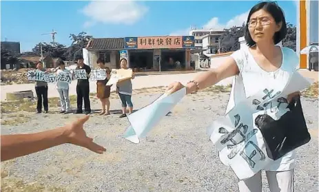  ?? Nanfu Wang ?? human rights lawyer Wang Yu is shown in 2013 handing out literature in the film “Hooligan Sparrow.”