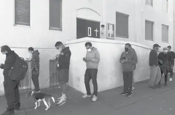  ?? JAE C. HONG/AP ?? People wait in line for a COVID-19 test Tuesday in Los Angeles. Experts warn that it is still too early, and there are not yet enough detailed data, to draw firm conclusion­s about the omicron variant’s inherent severity.