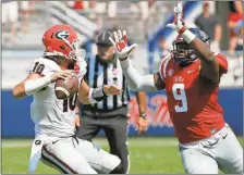  ?? Rogelio V. Solis / The Associated Press ?? Mississipp­i defensive tackle Breeland Speaks (right) rushes Georgia quarterbac­k Jacob Eason during the second half of Saturday’s game.