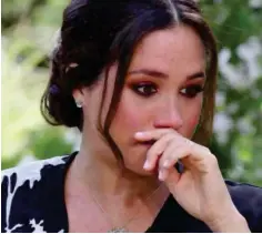  ??  ?? Emotional: Meghan wipes her eyes as she tells Oprah Winfrey about her battles with mental health. She told Harry about her suicidal thoughts hours before they